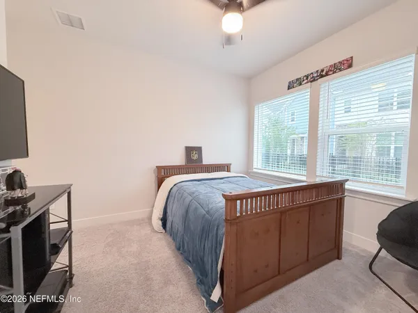 a spacious bedroom with a bed and a flat screen tv