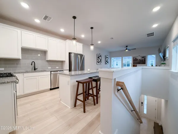 a kitchen with white cabinets and refrigerator