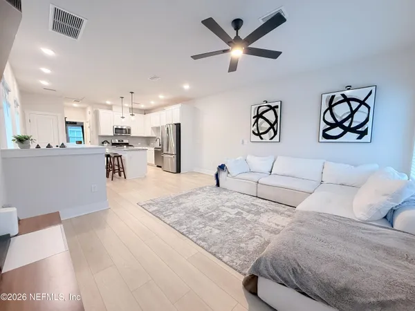 a living room with furniture and kitchen view