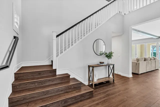 a kitchen with stainless steel appliances granite countertop a table chairs microwave and sink