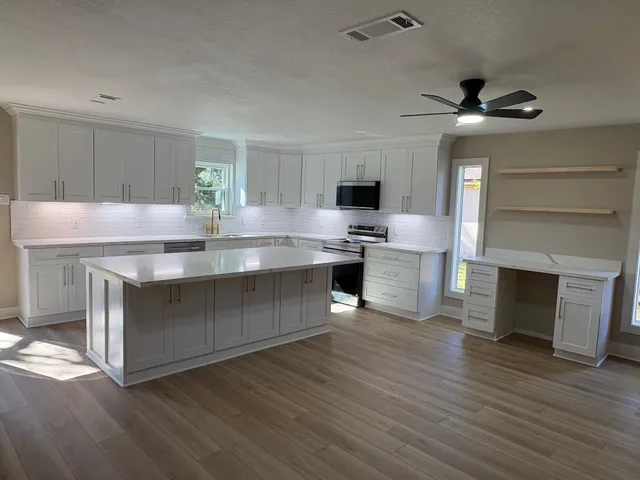 a kitchen with kitchen island a sink stainless steel appliances and cabinets