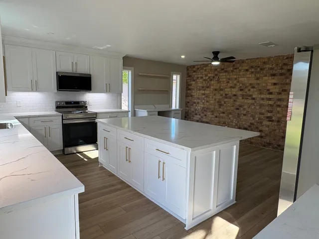 a kitchen with stainless steel appliances a stove microwave and sink