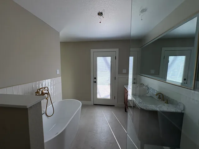 a en suite bathroom with a granite countertop sink and a mirror