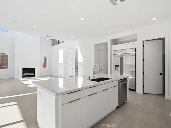 a kitchen with granite countertop a sink and white cabinets