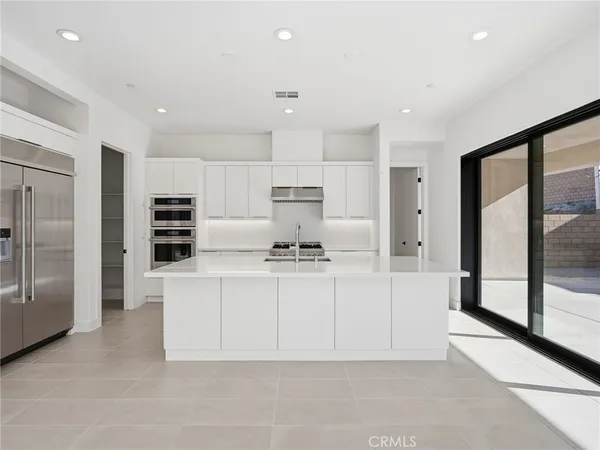 a large white kitchen with stainless steel appliances cabinets