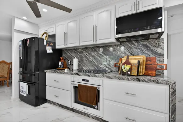 a kitchen with stainless steel appliances kitchen island granite countertop a sink and cabinets