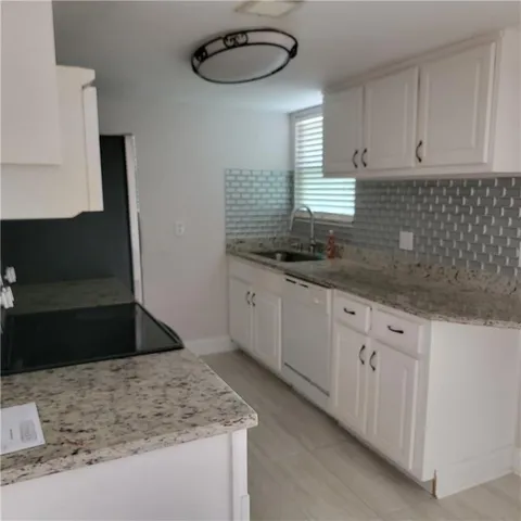 a kitchen with stainless steel appliances granite countertop a sink stove and cabinets