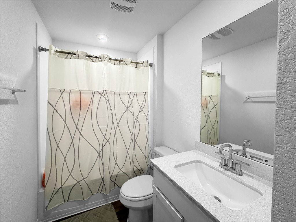 730 Gladiola Loop Kyle, TX 78640 - Photo 10 of 13 Full bathroom with shower / bath combination with curtain, vanity, and dark wood-style floors