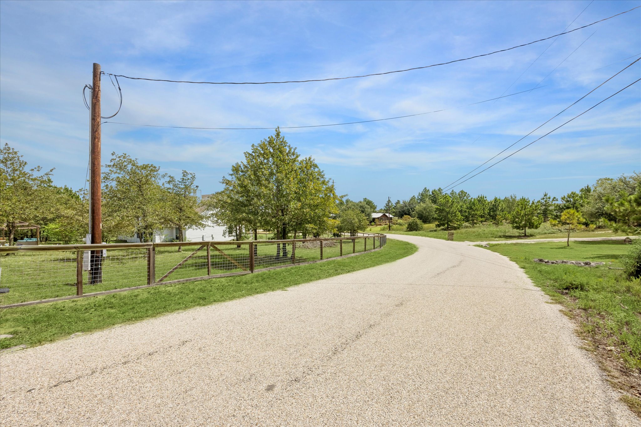 116 Mallard Road Bastrop, TX 78602 - Photo 29 of 31 Mature trees and a rustic fence line the quiet approach to this country property.
