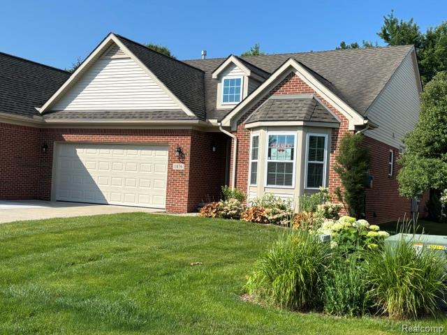 1876 Genoa Circle Howell, MI 48843 - Photo 1 of 36 Brick and siding exterior featuring a bay window, gabled rooflines, and an attached two-car garage