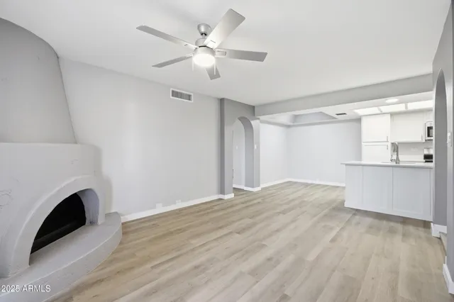 an empty room with windows and fireplace