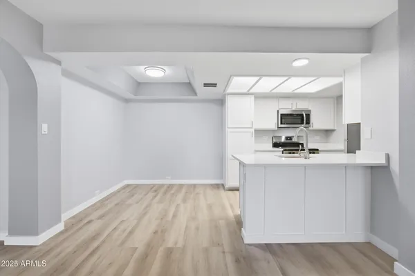 a view of a kitchen with a sink and a refrigerator