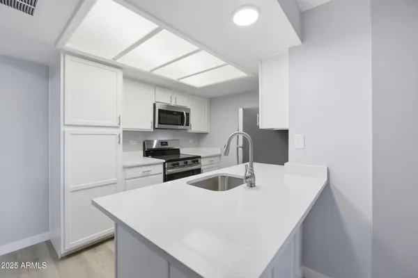 a kitchen with cabinets a sink and appliances