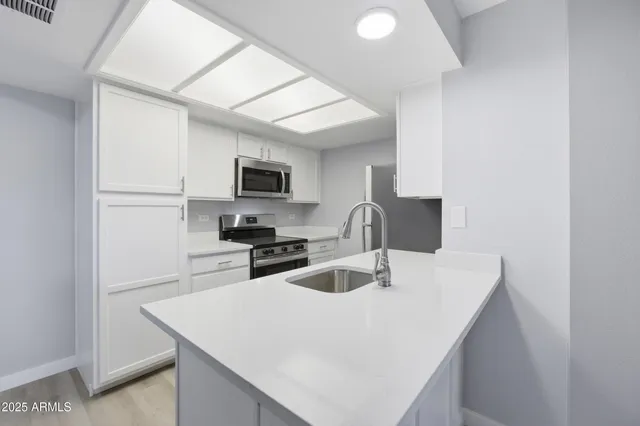 a kitchen with cabinets a sink and appliances