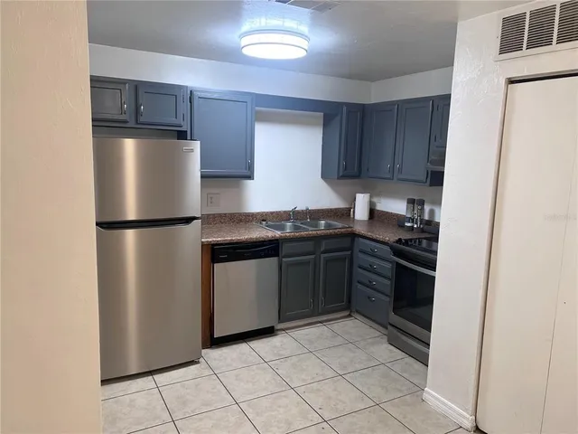 a view of kitchen with refrigerator and cabinets