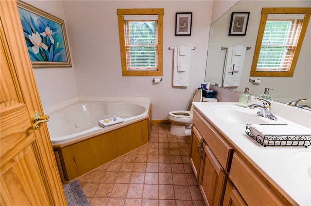 15 Alm Strasse Helen, GA 30545 - Photo 64 of 71 a bathroom with a sink a mirror a bathtub and a toilet