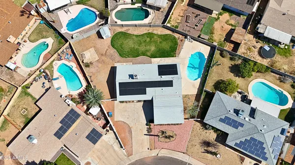 an aerial view of a house with swimming pool and outdoor seating
