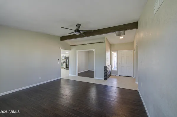 a view of a livingroom with wooden floor and a ceiling fan