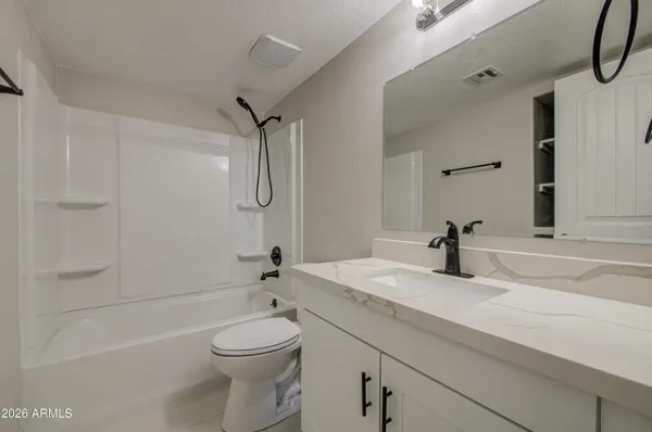 a bathroom with a granite countertop sink toilet and shower