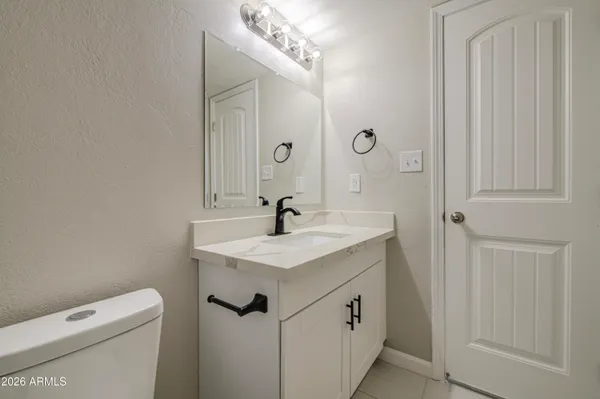 a bathroom with a sink a toilet and a mirror