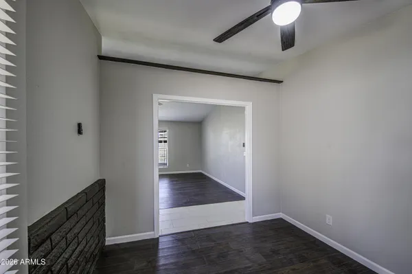 an empty room with wooden floor cabinet and windows