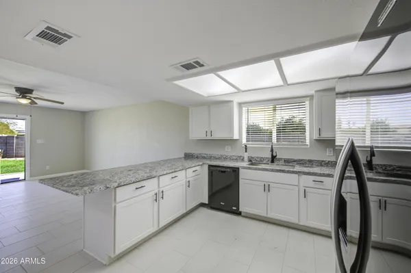 a kitchen with granite countertop sink a stove and chairs