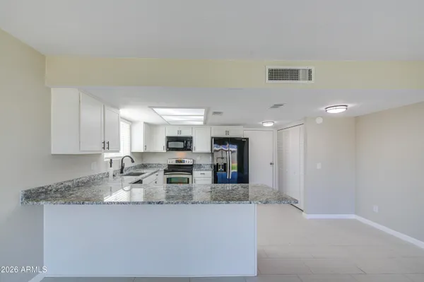 a kitchen with refrigerator and cabinets