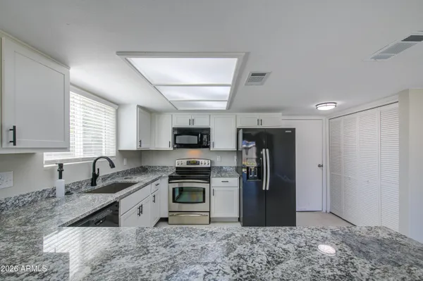 a kitchen with stainless steel appliances granite countertop a refrigerator stove top oven a sink and dishwasher