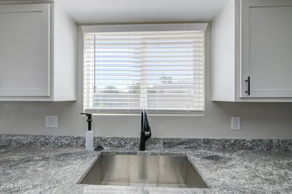 a kitchen with granite countertop a sink and a window