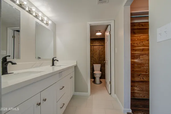 a spacious bathroom with a double vanity sink a mirror and a shower