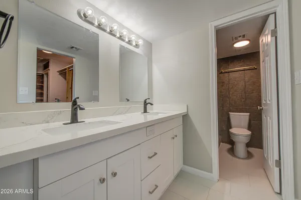 a spacious bathroom with a toilet sink and mirror