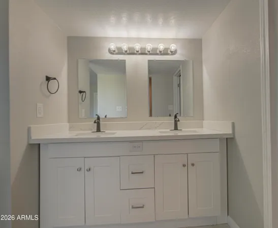 a bathroom with double vanity sinks and a mirror