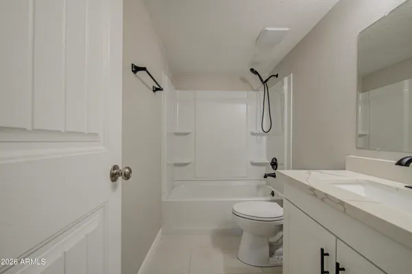 a bathroom with a granite countertop toilet a sink and a shower