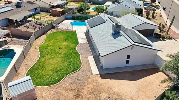 an aerial view of a residential houses with yard