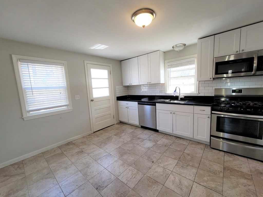 4 Allen Road Billerica, MA 01821 - Photo 2 of 24 a kitchen with granite countertop a stove sink and microwave