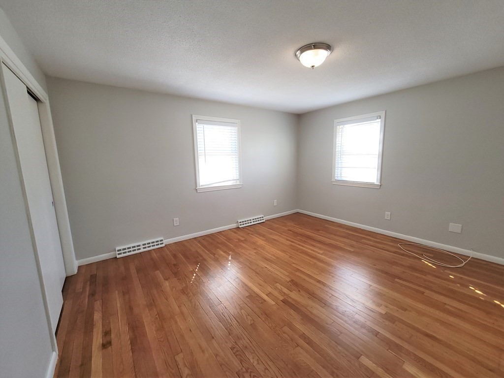 4 Allen Road Billerica, MA 01821 - Photo 9 of 24 an empty room with wooden floor and windows