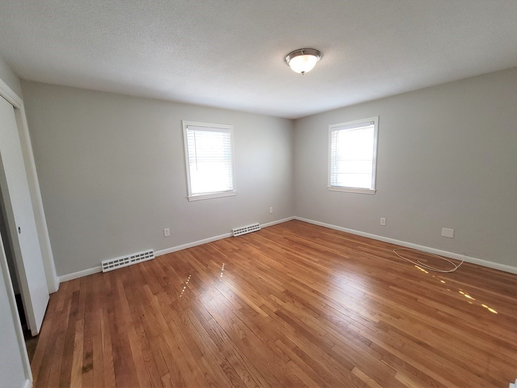 4 Allen Road Billerica, MA 01821 - Photo 10 of 24 an empty room with wooden floor and windows