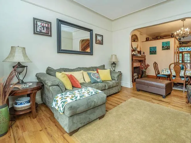a living room with furniture and painting on the wall