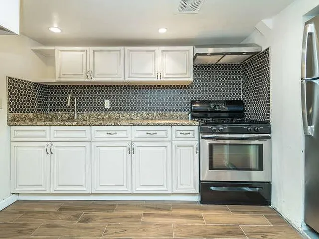 a kitchen with white cabinets and appliances