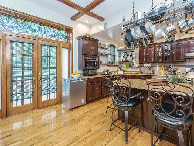 a kitchen with stainless steel appliances granite countertop a stove a sink and a microwave