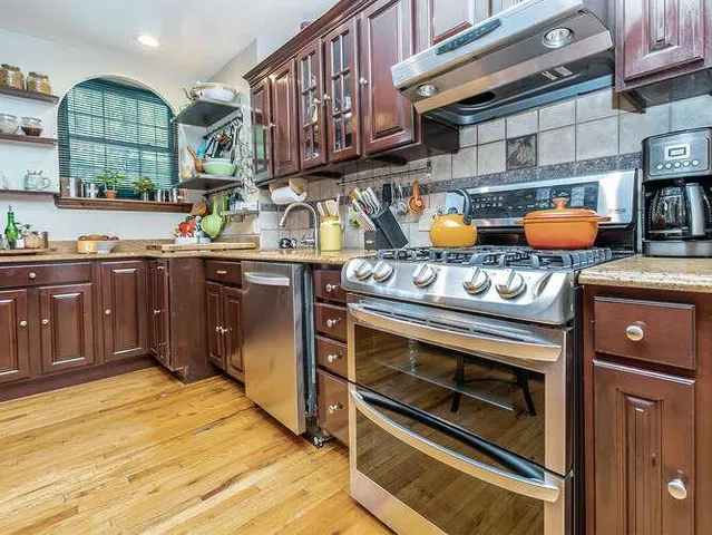 a kitchen with stainless steel appliances granite countertop a stove a sink and a microwave