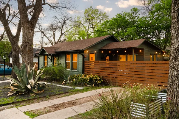 a front view of a house with a tree