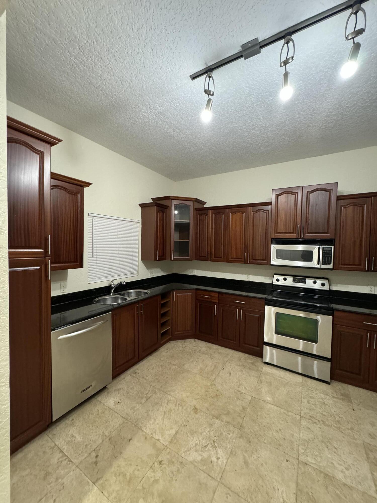 a kitchen with stainless steel appliances granite countertop a refrigerator and stove