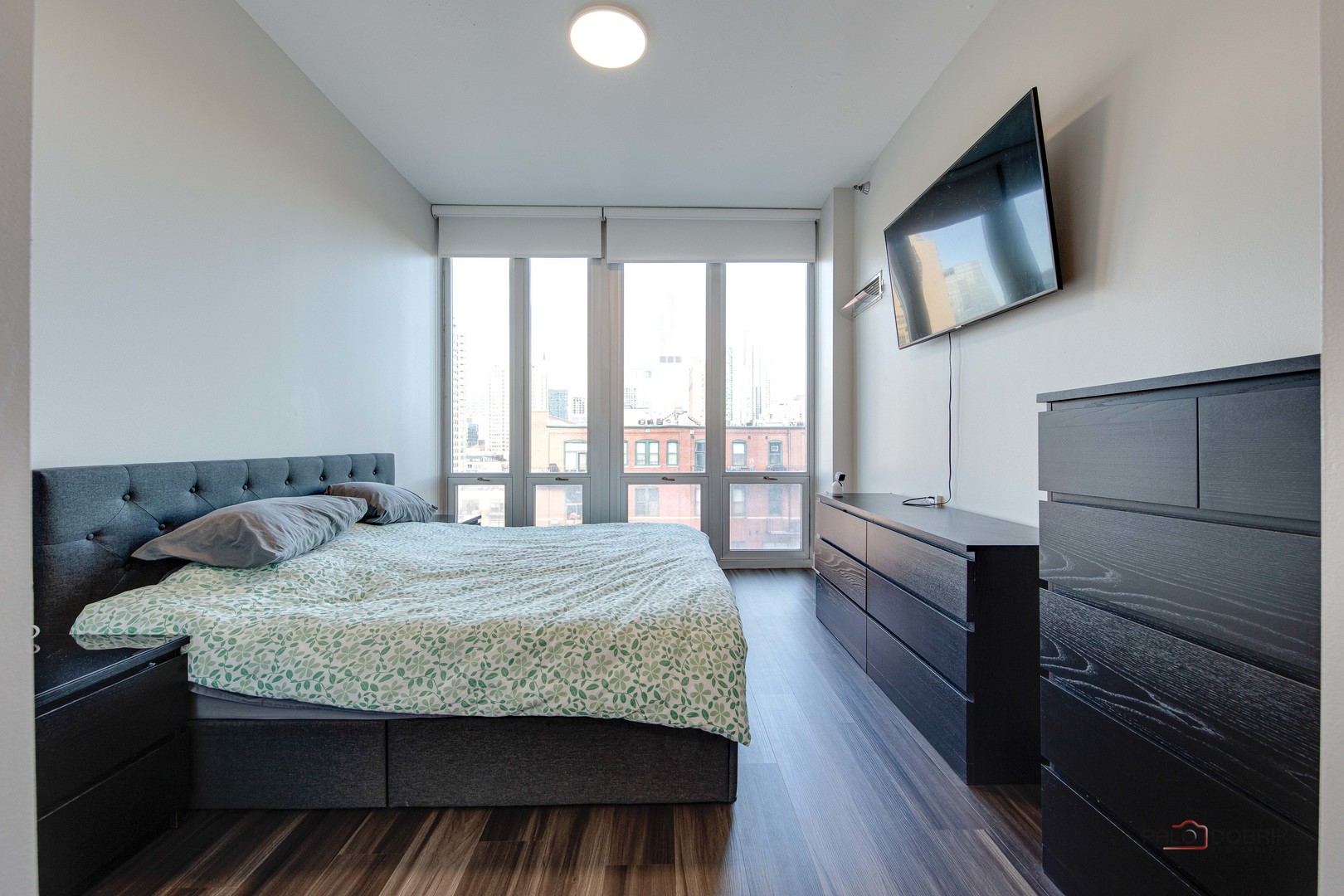 1600 South Indiana Avenue, Unit 803 Chicago, IL 60616 - Photo 14 of 24 a bedroom with a bed and wooden floor