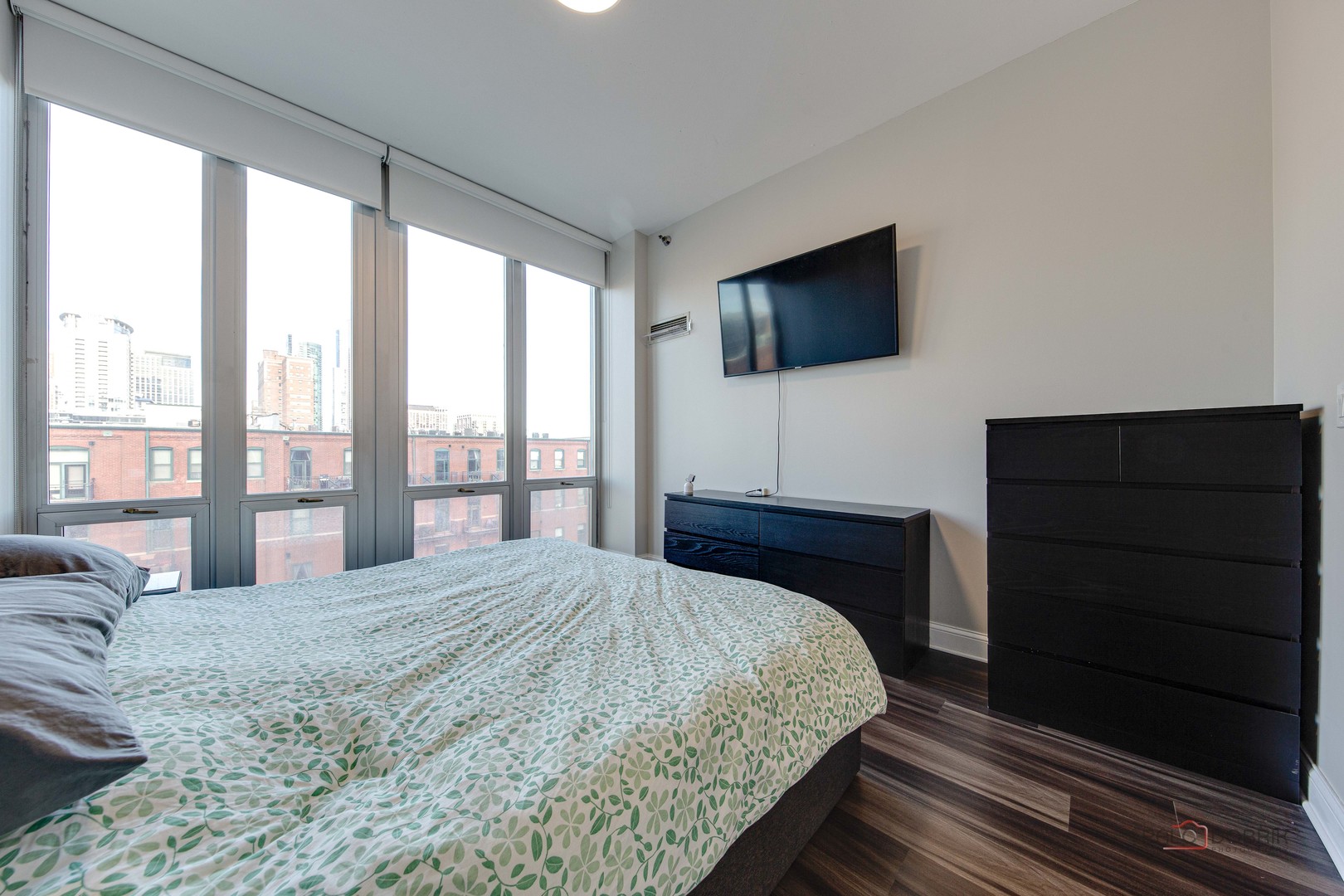 1600 South Indiana Avenue, Unit 803 Chicago, IL 60616 - Photo 15 of 24 a bedroom with a large bed and a flat tv screen on dresser