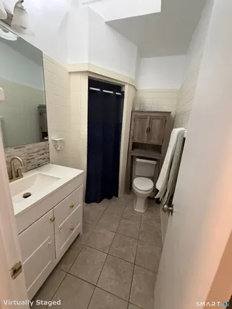 a bathroom with a sink a toilet and a mirror