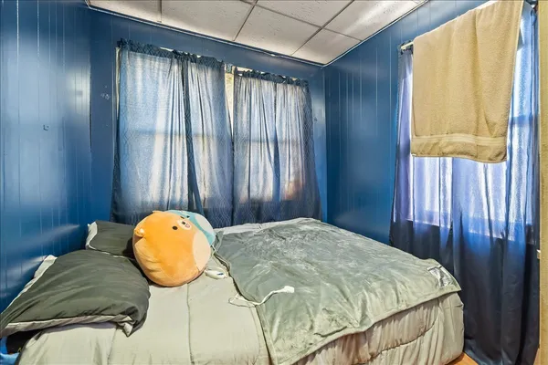 a bed sitting in a spacious bedroom next to a window