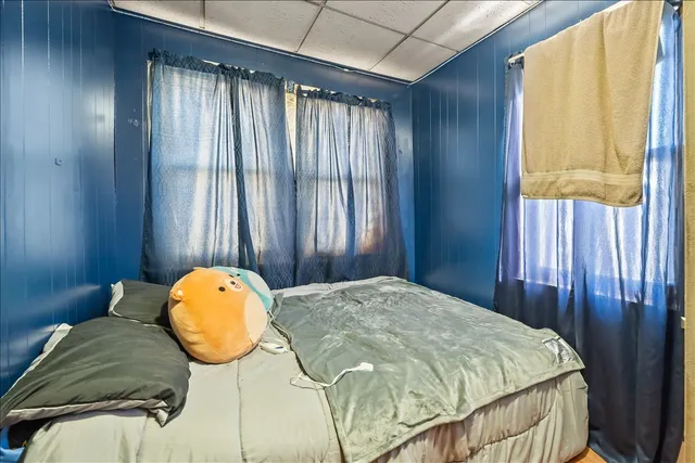 a bed sitting in a spacious bedroom next to a window