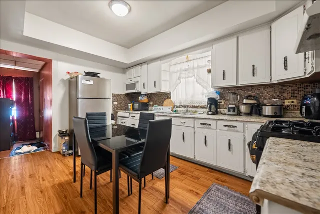 a kitchen with stainless steel appliances granite countertop a stove a sink dishwasher and a refrigerator with wooden cabinets