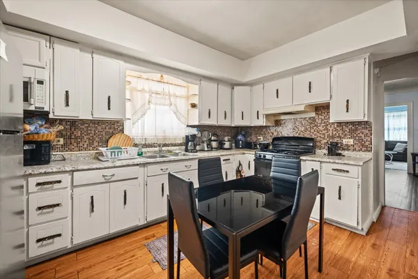 a kitchen with granite countertop white cabinets sink and stainless steel appliances